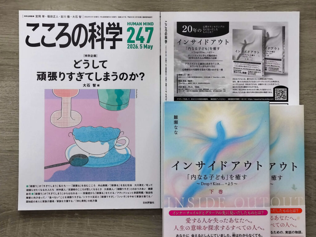 A photograph showing the May 2026 issue (No. 247) of the psychology magazine Kokoro no Kagaku alongside the two-volume book Inside Out: Healing the Inner Child – From “Drop+Kiss…+”. The magazine includes a page where the book appears, presented together with the physical copies.